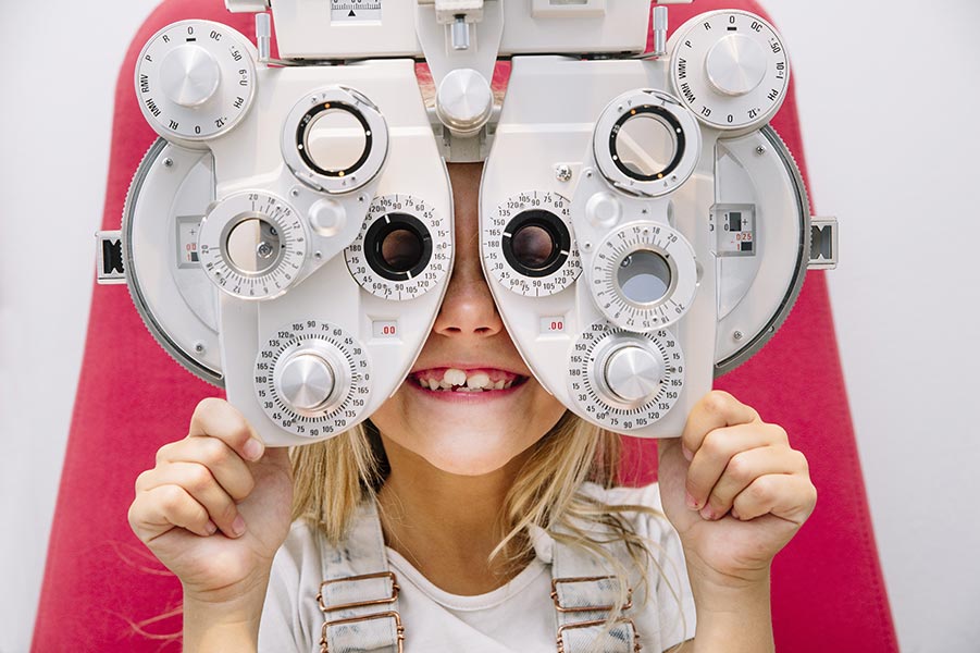 A girl receives a pediatric eye exam with her pediatric eye care doctor