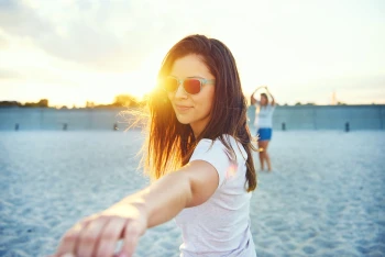 Woman wearing sunglasses at sunrise or sunset