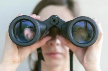 A woman looks through binoculars