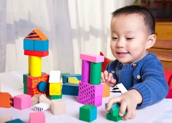 A boy plays with blocks and improves his hand-eye coordination