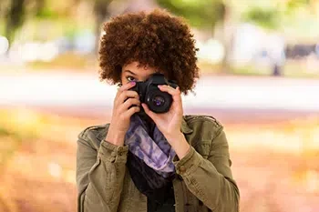 Woman holding camera, similar to retina care