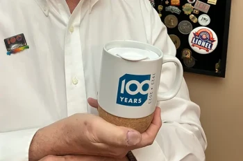 CEENTA 100th anniversary mug held by Dr. David Magee