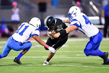 Football player being tackled and at risk of concussion.