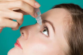 A woman with a corneal ulcer uses eye drops