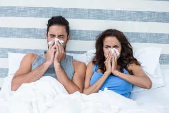 A couple in their bedroom has allergies