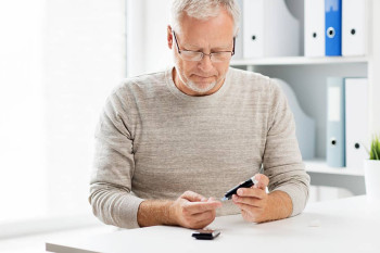 A diabetic man checks his blood sugar levels