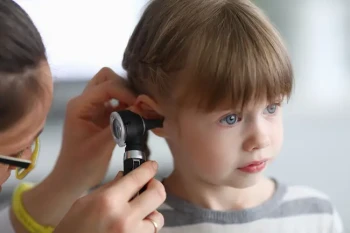 A boy has his ear checked and asking do ear infections go away on their own