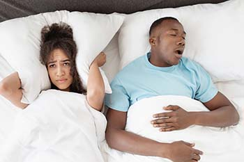 Man snoring next to wife