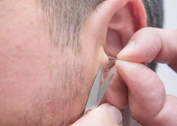 A man clips his ear hair