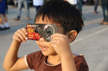 Child wearing eclipse glasses