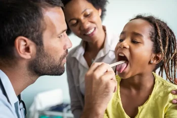 Child receiving tonsil exam