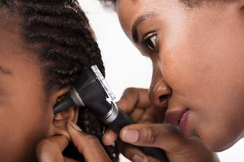 ENT specialist examining a child with an ear infection