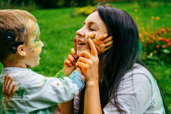 A happy child with a cochlear implant can hear during Kids ENT Health Month.
