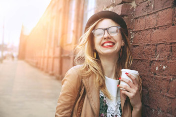 A happy woman wearing glasses after an eye exam at CEENTA.