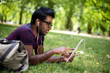 A man watches Five on Friday while outside.