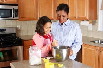 A mother and daughter cooking safely.