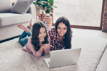 A mother and daughter watch a livestreaming event on Facebook.