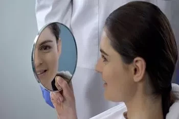 Nose job patient looking at the effects of her rhinoplasty