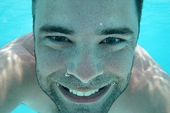 Man swimming with eyes open in the water. Salt water may affect eyes