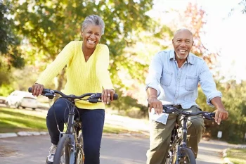 An older couple rides their bikes after FLACS surgery.