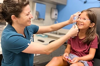 Pediatric eye doctor examining child patient