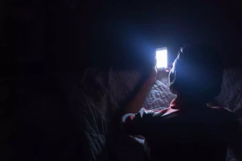 A person uses their phone at night.