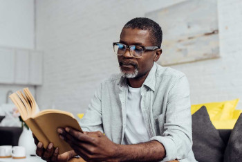 A man wears reading glasses