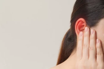 Woman wondering why her ears are red, a symptom of red ear syndrome