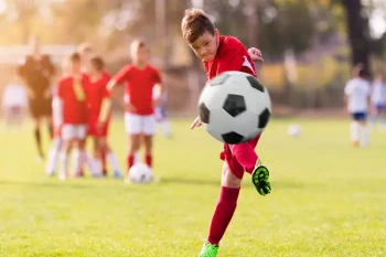 Child playing soccer and avoiding facial injuries