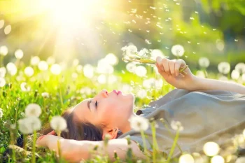 Woman laying in field not dealing with spring allergies