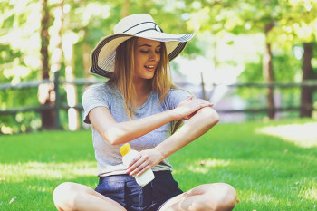 A woman applies sunblock