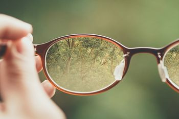 Person holding glasses correctly to avoid damaging eyewear