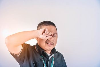 A man rubbing his eyes. His eye condition can be treated at home