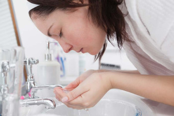 A woman washes her eyes