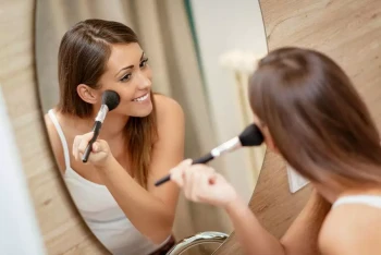 A woman applies makeup after cosmetic surgery and laser skin resurfacing