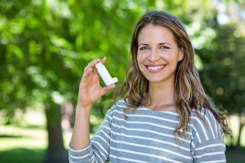 A woman with asthma holds an inhaler