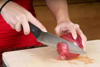 A woman cuts an onion