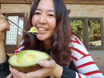 A woman eats an avocado to help with her allergies