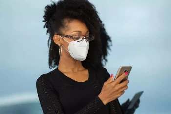 A woman wears a face mask with glasses.