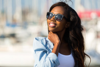 A woman wears sunglasses and protects her eyes from UV rays