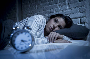 A woman with insomnia and tinnitus can't sleep