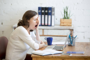 A woman's eyes water as she yawns