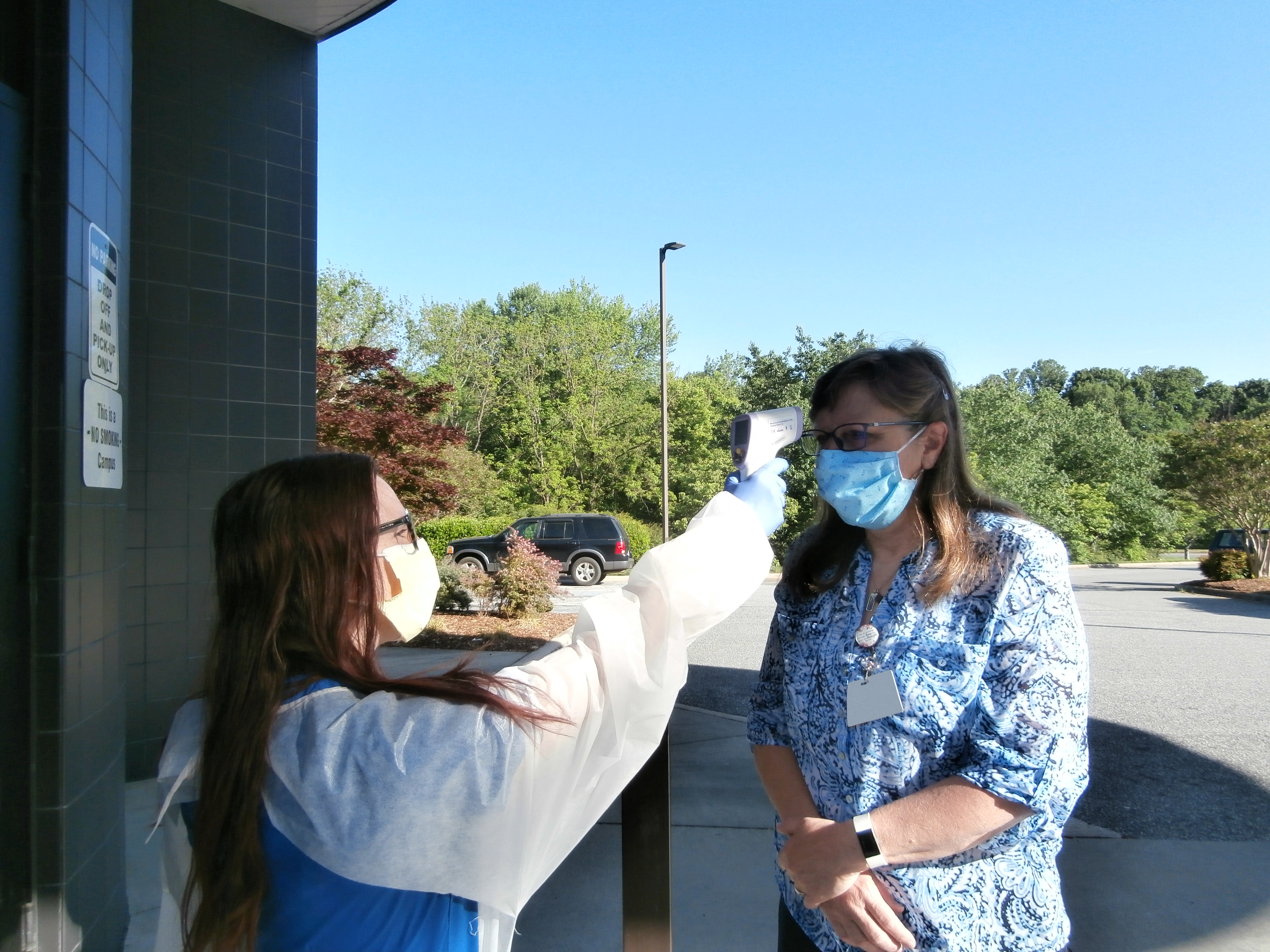 Taking temperatures and wearing masks at CEENTA