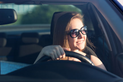 Girl in car wearing sunglasses to lower glare while driving